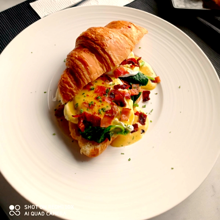 egg benedict croissant with bacon poached egg spinach and hollandaise sauce