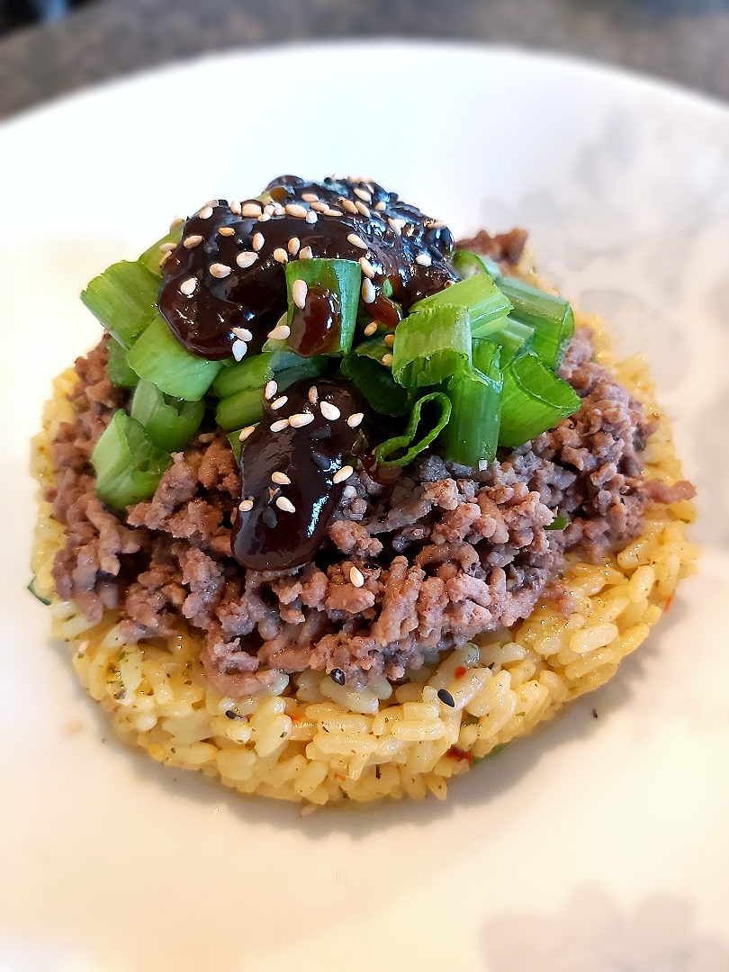BentoFox's dish Garden vegetable long grain rice, topped with seasoned ground beef, green onions, a sweet chili miso paste and sesame seeds.